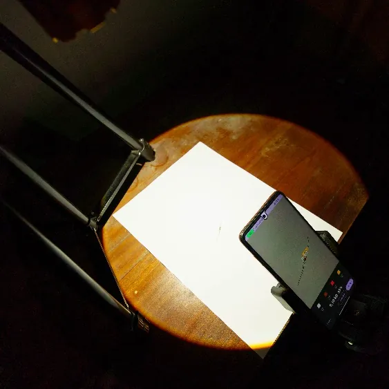 Ponsel pada tripod di atas resistor dengan lampu sorot